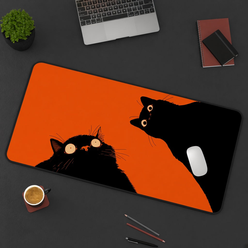 Two Black Cats on a Bright Orange Desk Mat