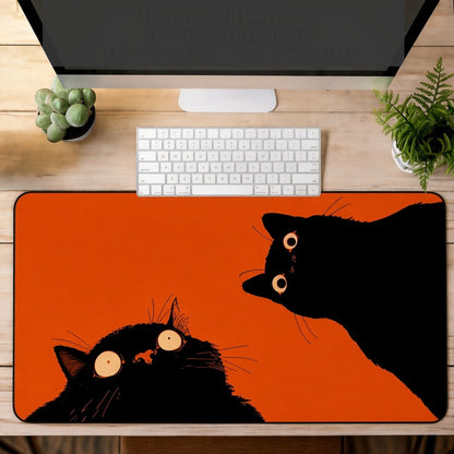 Two Black Cats on a Bright Orange Desk Mat